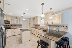 A modern kitchen with a central island, pendant lighting, and built-in appliances.