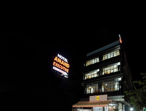 Un edificio con un cartel que dice "HOTEL ANAND EXECUTIVE A/C ROOM".