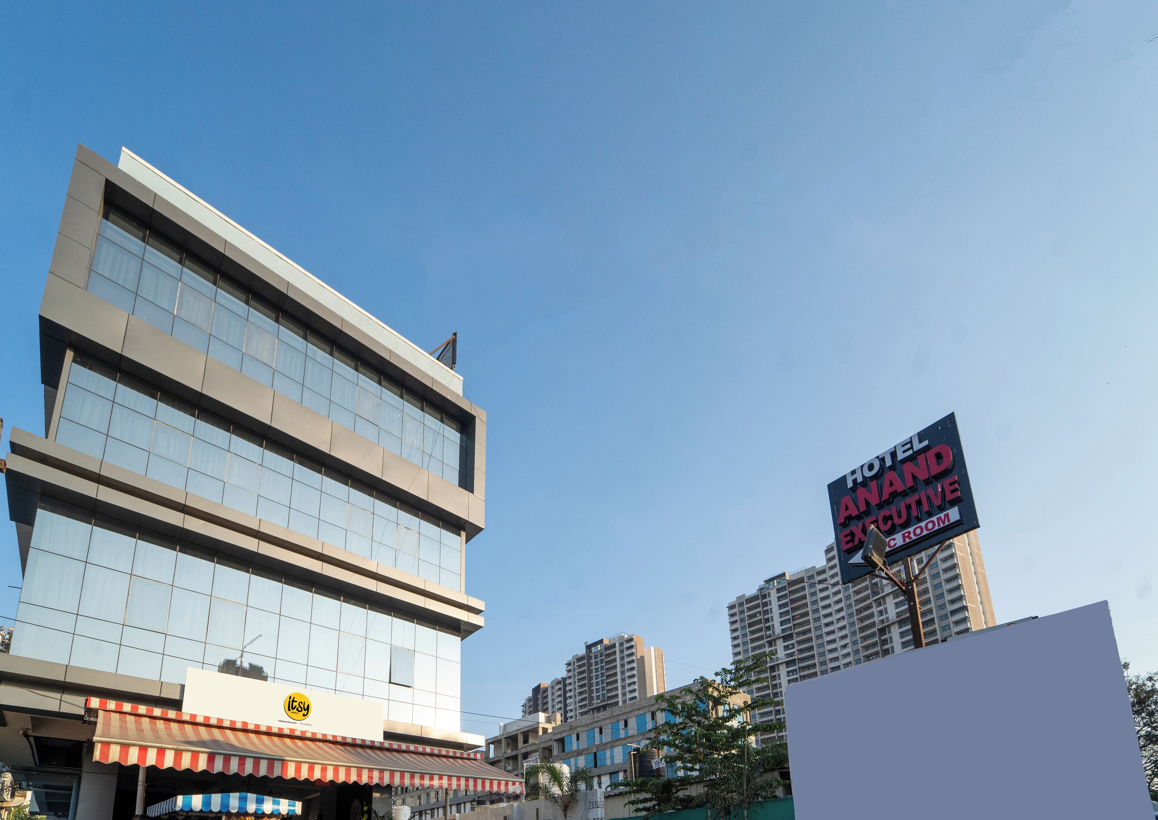 Un hôtel moderne, avec une grande façade en verre et une enseigne indiquant la présence de chambres de luxe.