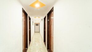 Un pasillo con suelo de mármol, puertas de madera e iluminación empotrada.