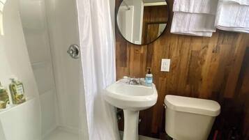 A bathroom with a shower, a sink, and a toilet.