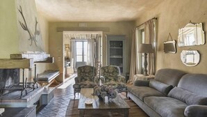 A cozy living room with a fireplace, a sofa, armchairs, and a coffee table.