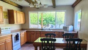 A kitchen with a dining table, chairs, a stove, and cabinets. - Cozy little cabin in the heart of Hells Canyon, with boat parking. (Halfway)