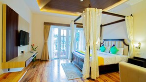A bedroom with a four-poster bed, a television, a desk, and a large window. - Treebo Greenland Resort Patia with Swimming Pool (Bhubaneshwar)