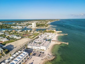 A coastal hotel with multiple buildings, a marina, and a beach.
