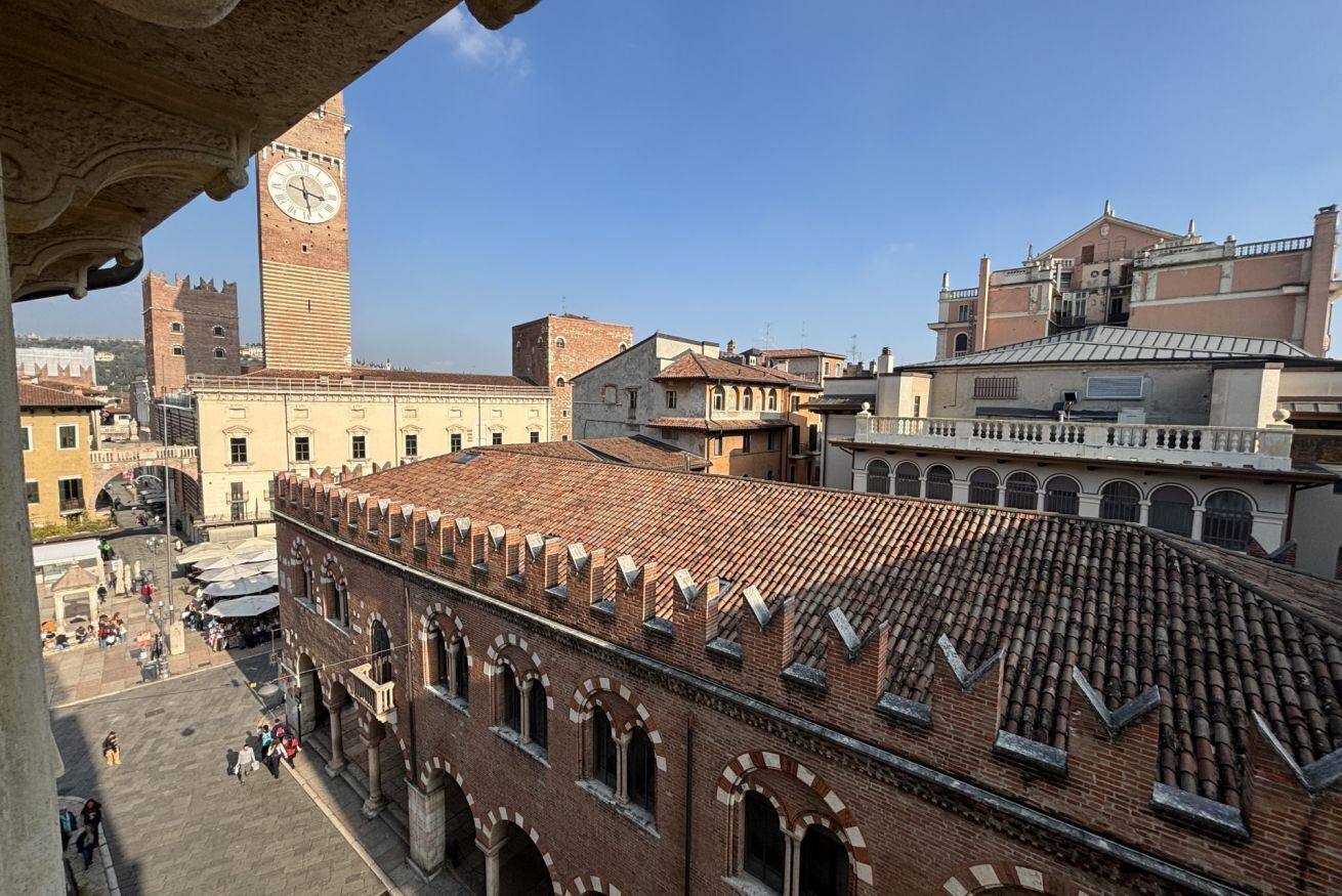 A historic building with a clock tower, arched windows, and a tiled roof.