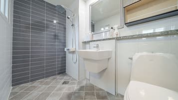 A modern bathroom with a shower, sink, and toilet.