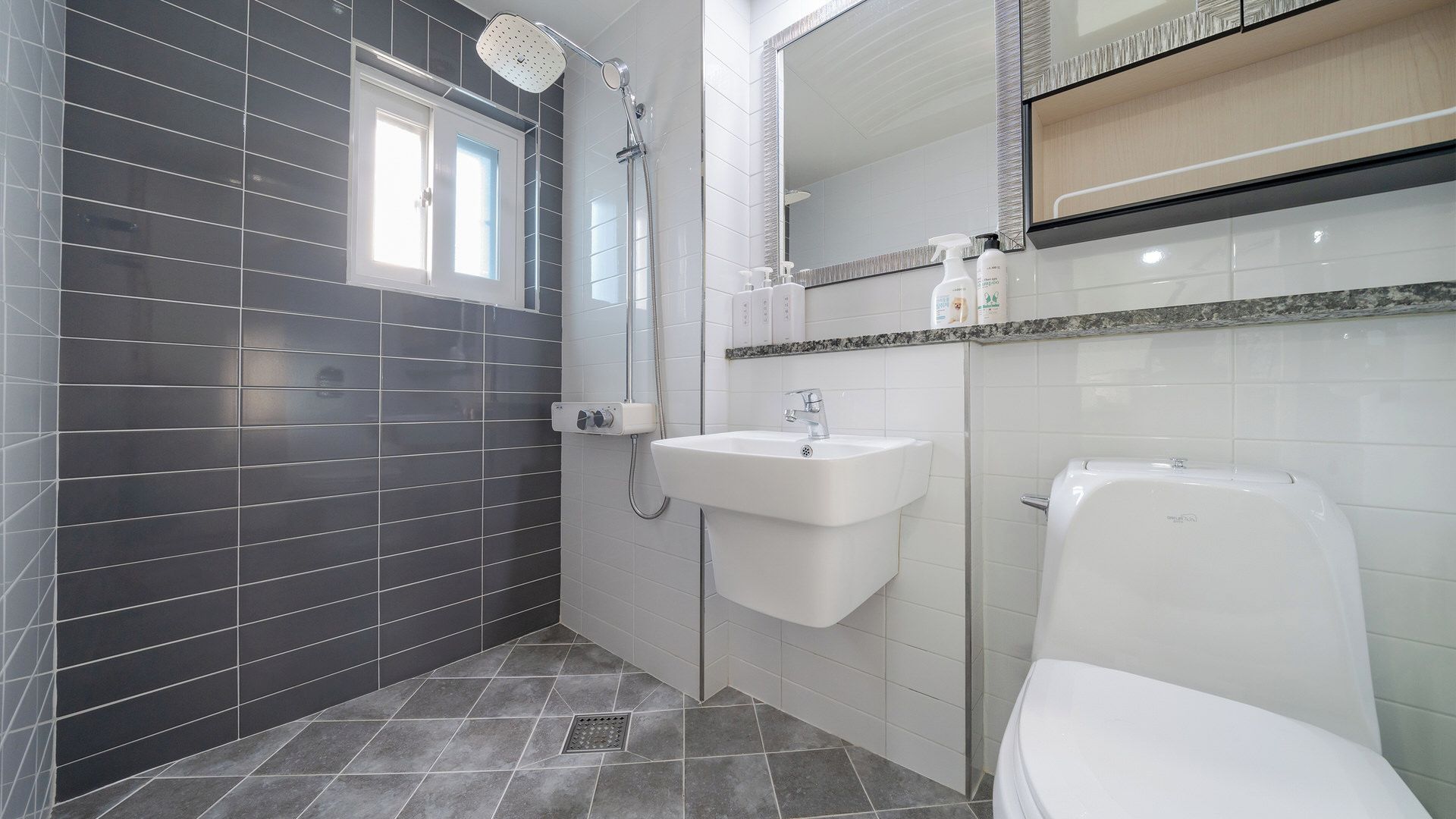 A modern bathroom with a shower, sink, and toilet.
