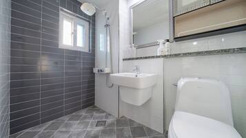 A modern bathroom with a shower, sink, and toilet.