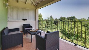 A balcony with wicker furniture and a view of greenery. - Villa mit Klimaanlage und Pool (Krnica)
