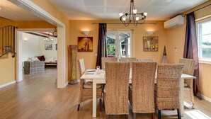 A dining area with wicker chairs, a white table, and a chandelier. - Villa mit Klimaanlage und Pool (Krnica)
