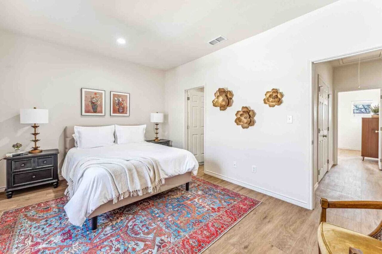 Une chambre à coucher avec un lit, des tables de chevet, un tapis et des éléments de décoration murale.