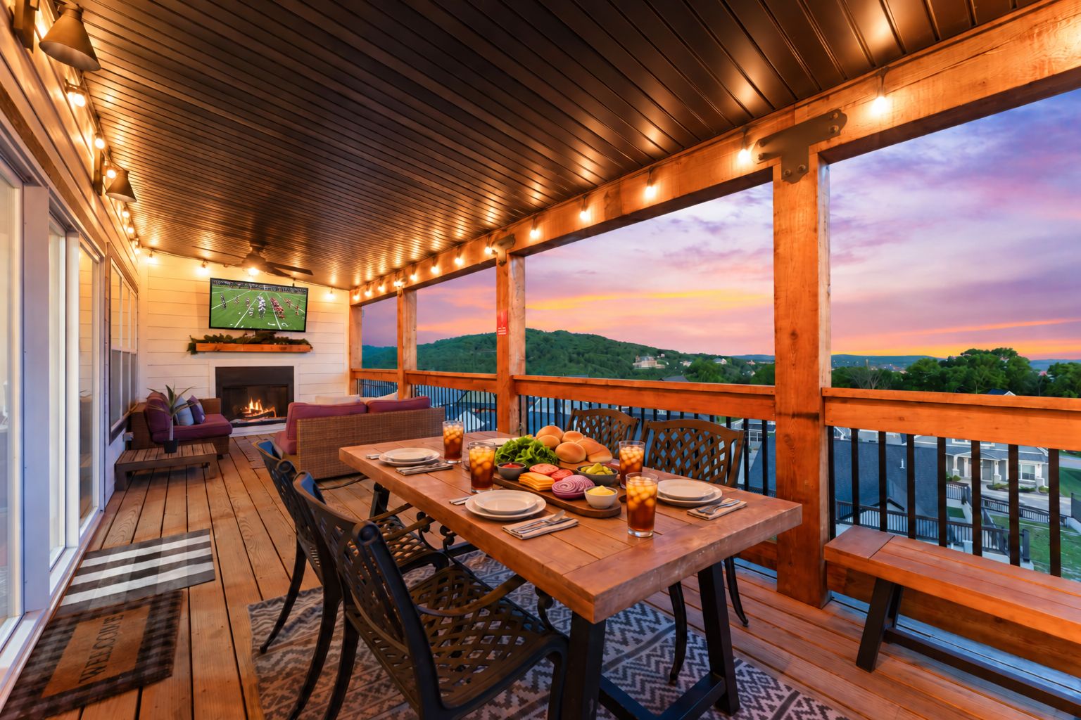 An outdoor deck with a dining table set for a meal, surrounded by chairs, and a television mounted on the wall.
