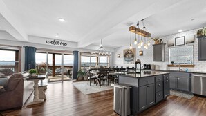 A spacious kitchen with a central island, dark cabinetry, and a view of the outdoors.
