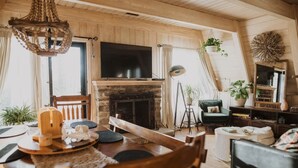 A cozy living room with a fireplace, wooden furniture, and a television.
