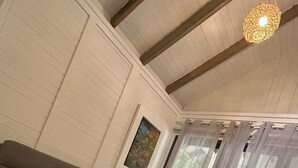 Una habitación con un sofá gris, una mesa blanca y una lámpara colgante.