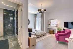 Une chambre à coucher moderne avec un lit, une table de chevet et une chaise rose.