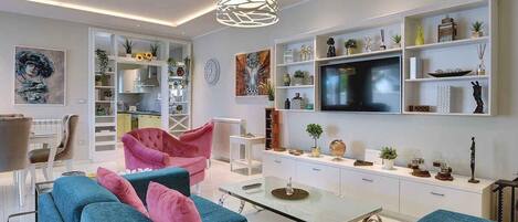 A modern living room with a sofa, chairs, a coffee table, and a TV.
