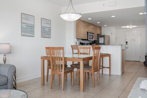 A modern kitchen with wooden cabinets, a built-in microwave, and a refrigerator.