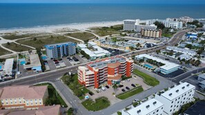 A coastal hotel with multiple floors, a swimming pool, and a view of the beach.