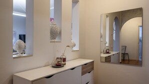 A modern bathroom with a white vanity, a mirror, and a window.