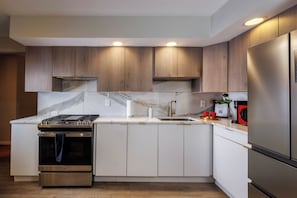 Eine moderne Küche mit Einbauofen, Edelstahlkühlschrank und Holzausstattung.