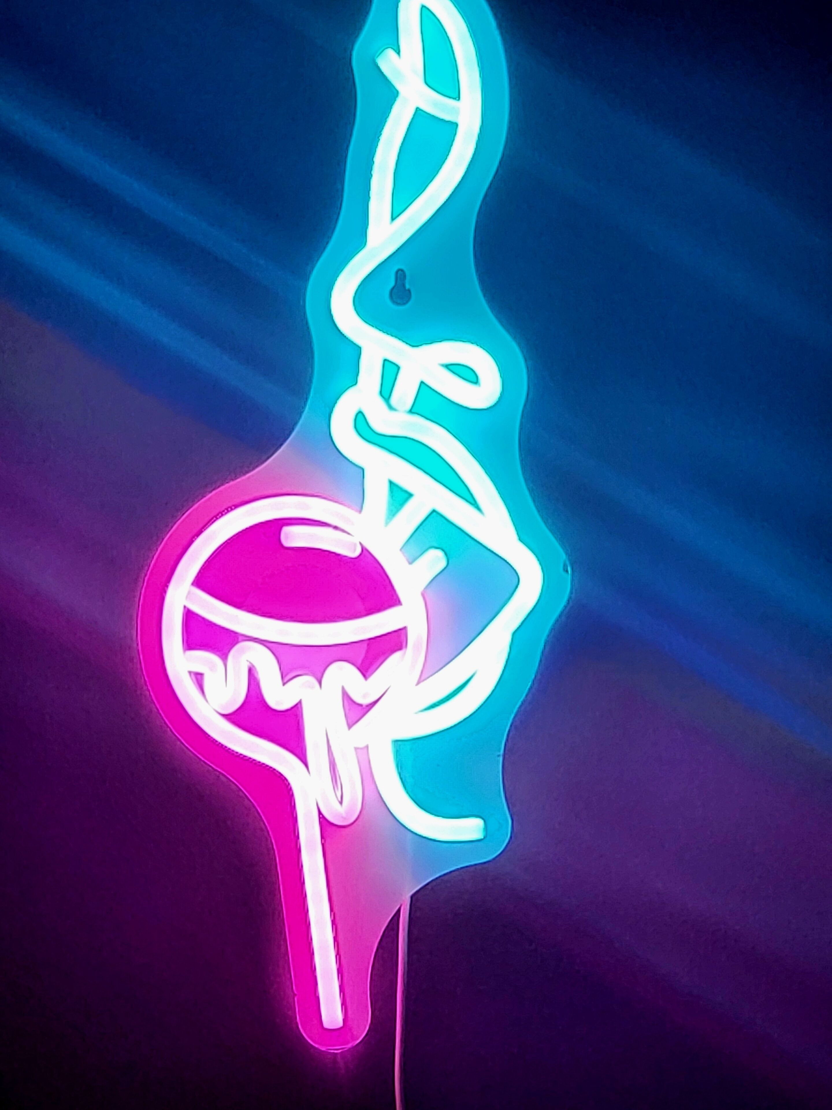 A neon sign with a stylized design, possibly representing a logo or symbol.