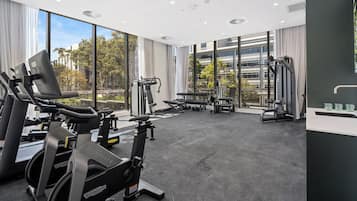 A gym with cardio machines, weight benches, and free weights.
