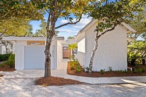 A modern house with a garage, a well-maintained garden, and a clear sky. - Beach Front Seagrove Cottage in 30A (Santa Rosa Beach)