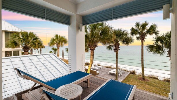 Een strandlounge met een pooltafel, loungezetels en uitzicht op de oceaan.