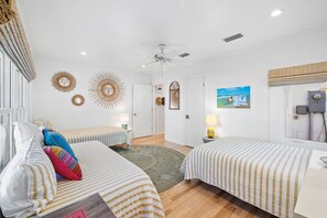 A hotel room with two beds, a ceiling fan, decorative wall art, and a view of the beach. - Beach Front Seagrove Cottage in 30A (Santa Rosa Beach)