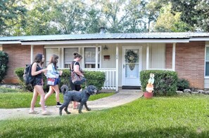 A house with a front porch, a mailbox, and a small garden with a statue.