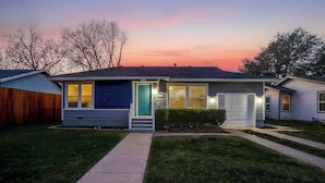 Ein Bungalow mit Garage, einer sichtbaren Tür und einem kleinen Vorgarten.