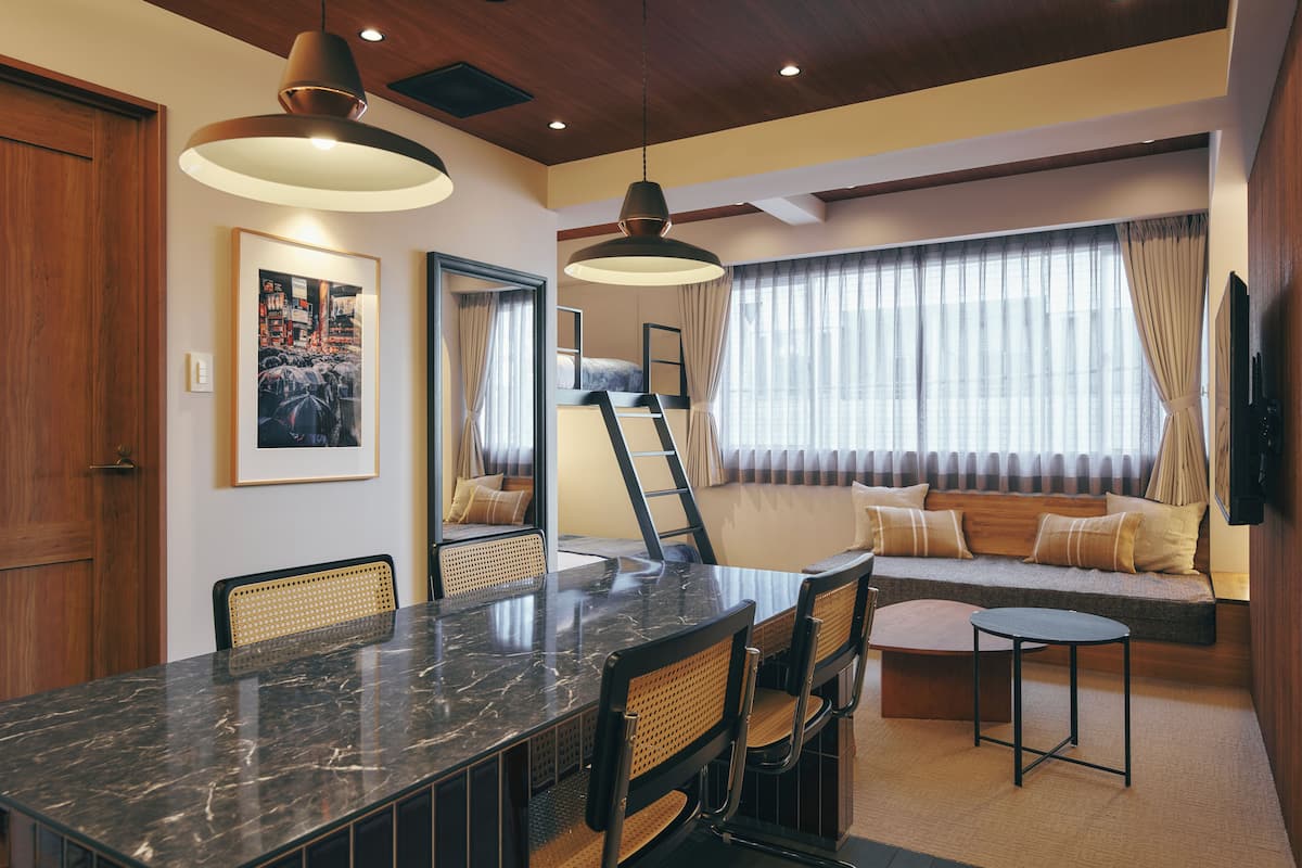 A dining area with a marble table, wicker chairs, and pendant lighting.