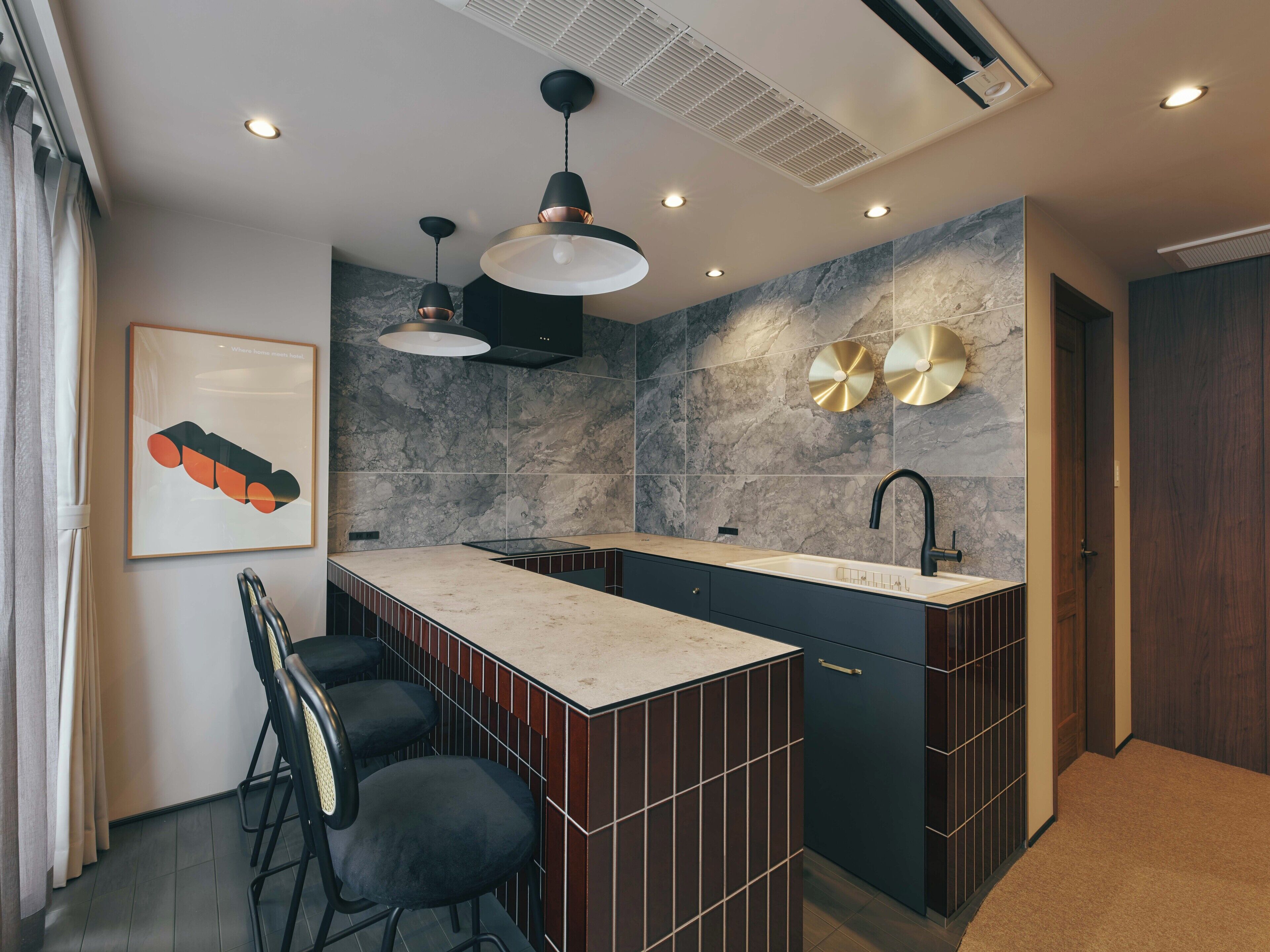 A modern kitchen with a marble backsplash, pendant lighting, and a central island with bar stools.