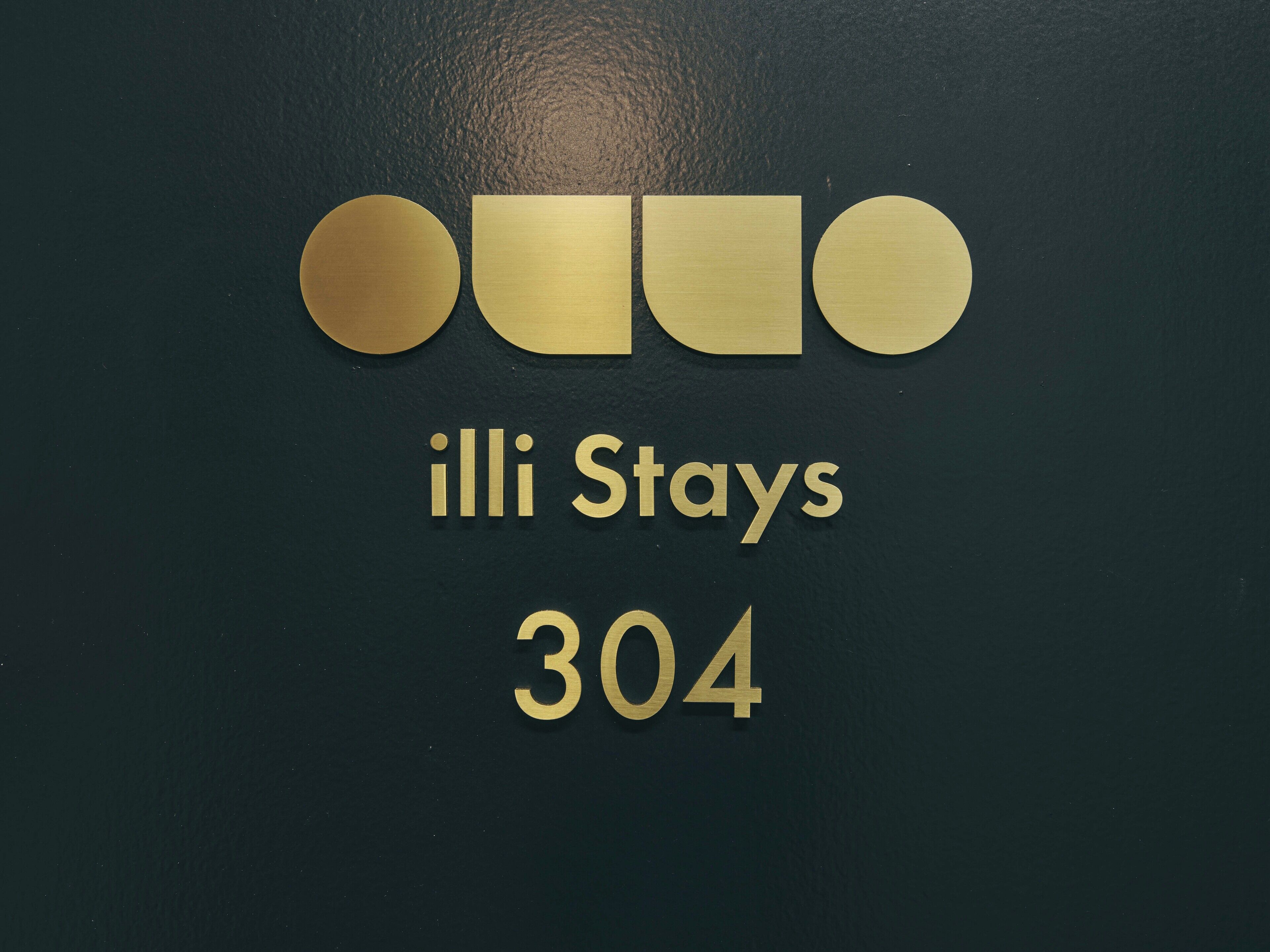 A sign with the text "illi Stays 304" on a dark background.