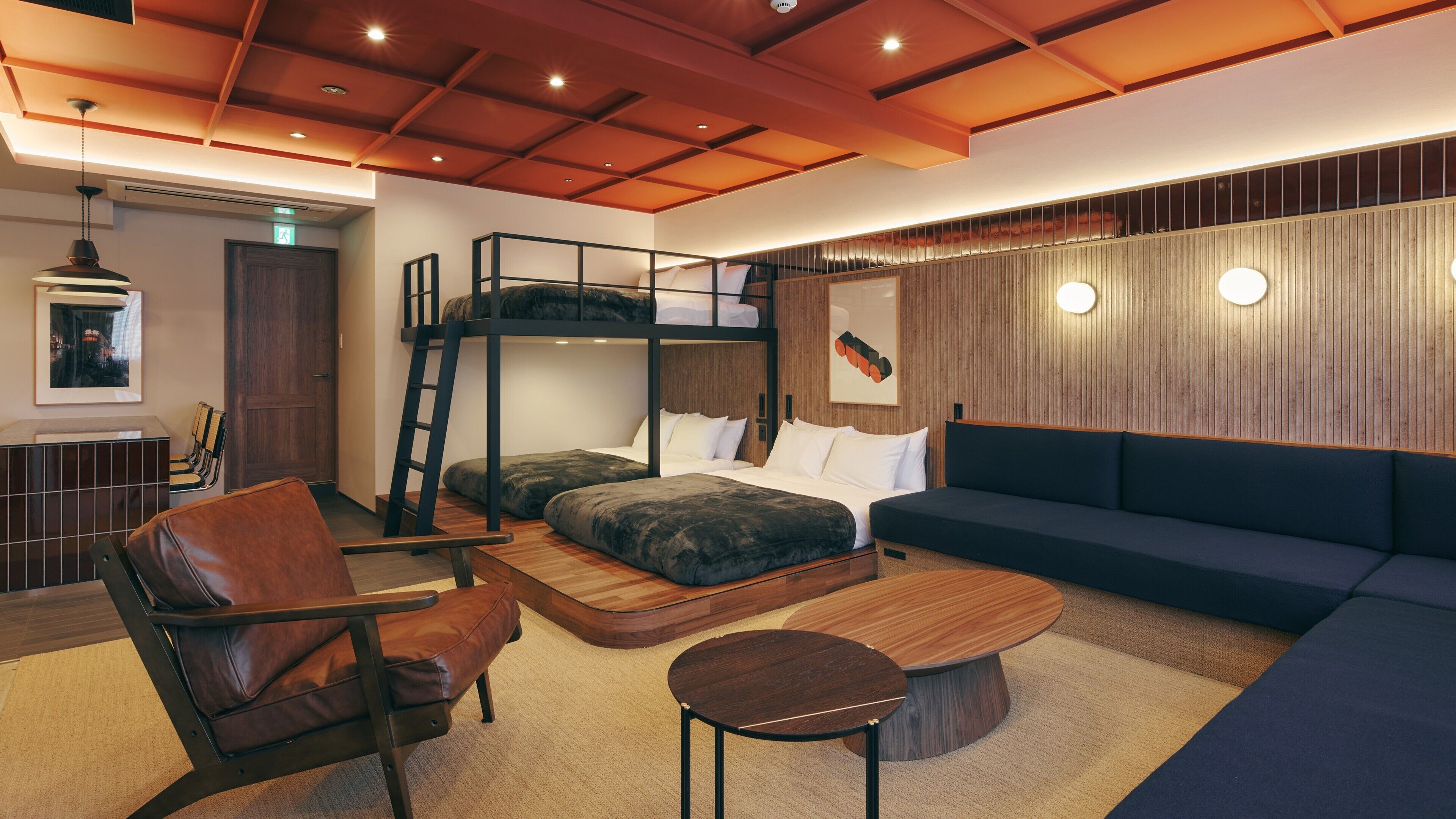 A modern interior with bunk beds, a sofa, a coffee table, and a chair.