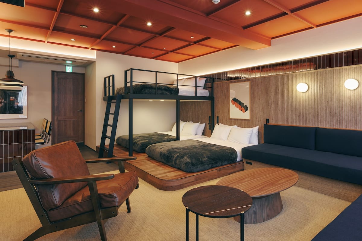 A modern interior with bunk beds, a sofa, a coffee table, and a chair.