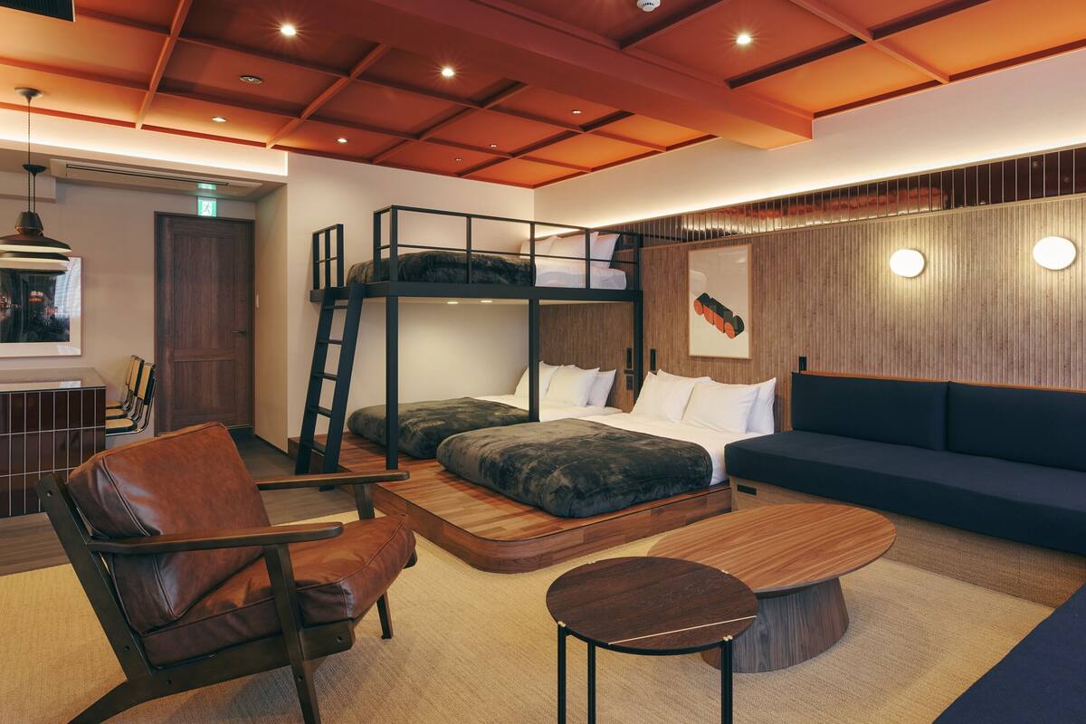 A modern interior with bunk beds, a sofa, a coffee table, and a chair.
