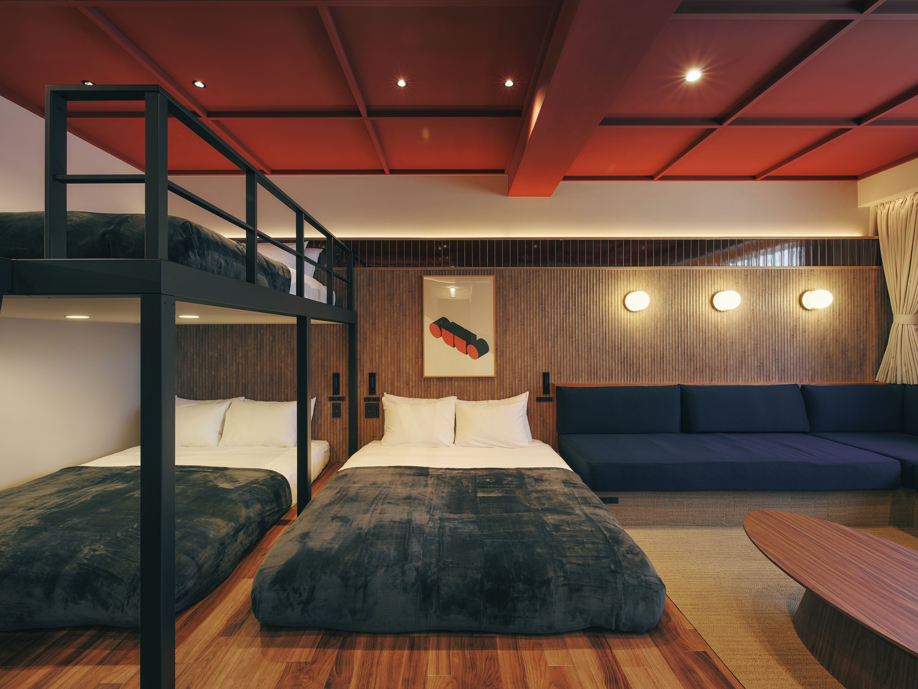 A modern room with bunk beds, a sofa, and a wooden floor.