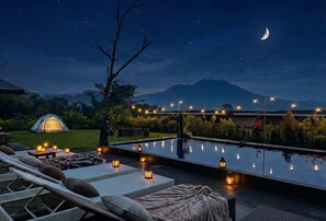 Una piscina al aire libre, sombrillas, tumbonas
