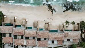 A beachfront hotel with multiple balconies, a swimming pool, and a sandy beach. - The Six Weligama (Ahangama)