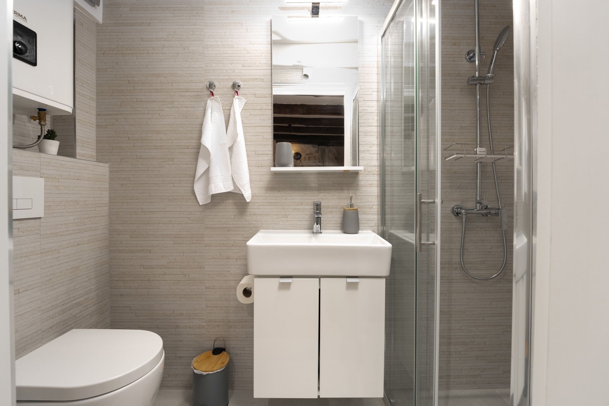 Un bagno moderno con toilette, lavabo e doccia.