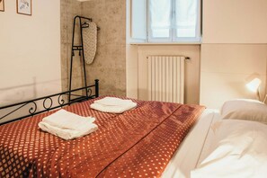 Une chambre d’hôtel avec un lit, un radiateur et une fenêtre.