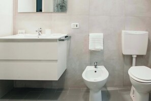 Ein modernes Badezimmer mit Waschbecken, Bidet und Toilette.