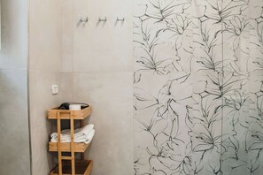 Een badkamer met een houten plank met handdoeken en een handdoekhouder erboven.