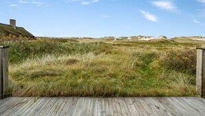 A wooden deck leading to a grassy field with a clear sky. - "Fausta" - 150m from the sea by Interhome (Ringkøbing)
