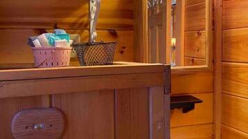 Ein Badezimmer aus Holz mit Waschbecken, Spiegel und zwei Wandleuchten.