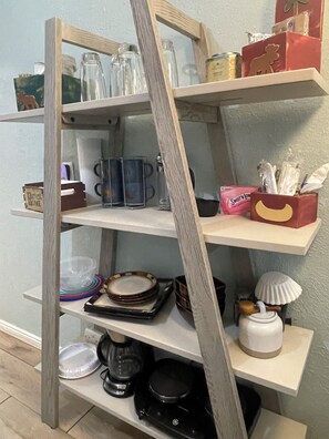 A wooden shelf unit with various kitchen items and storage boxes. - Simple luxury in a country setting  (Idaho Falls)