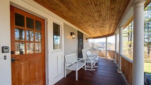 A covered porch with wooden columns, white railings, and white rocking chairs. - Sunsets On Blue Hill, Newly Renovated Farmhouse (Great Barrington)